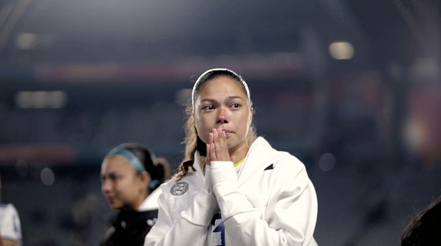 Woman listening to her phone in front of a bookcase