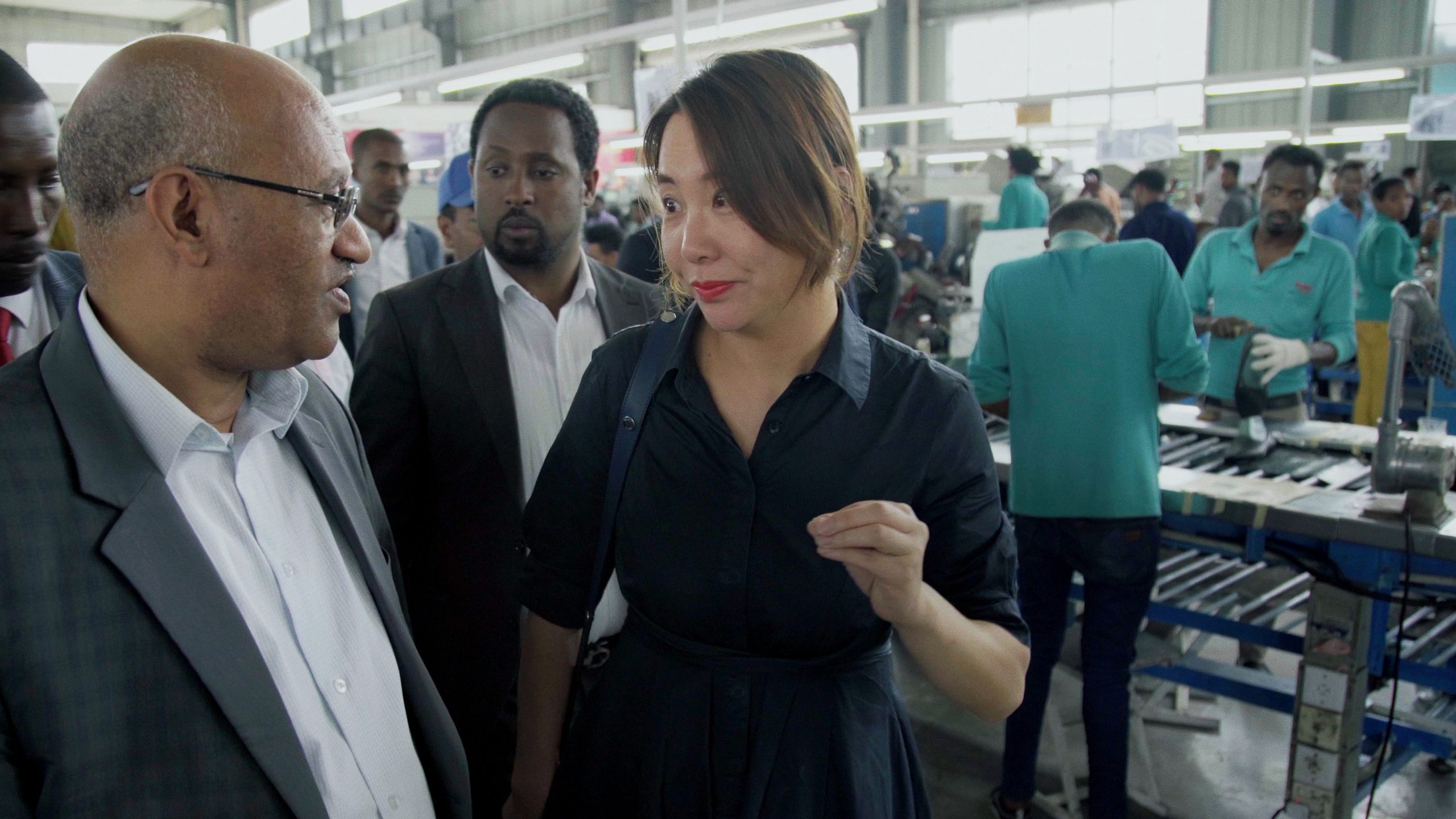 Woman talking to a man in a factory. 