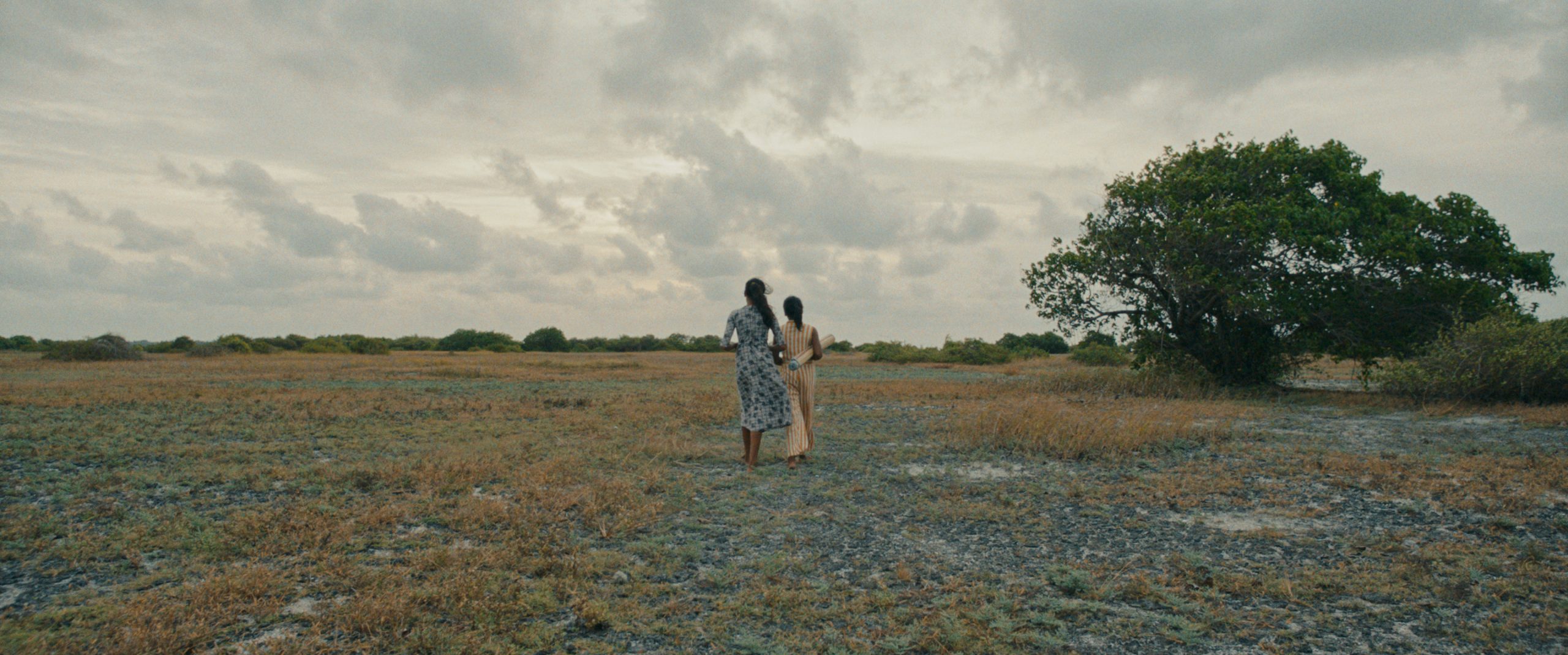 Two women are in a field. 