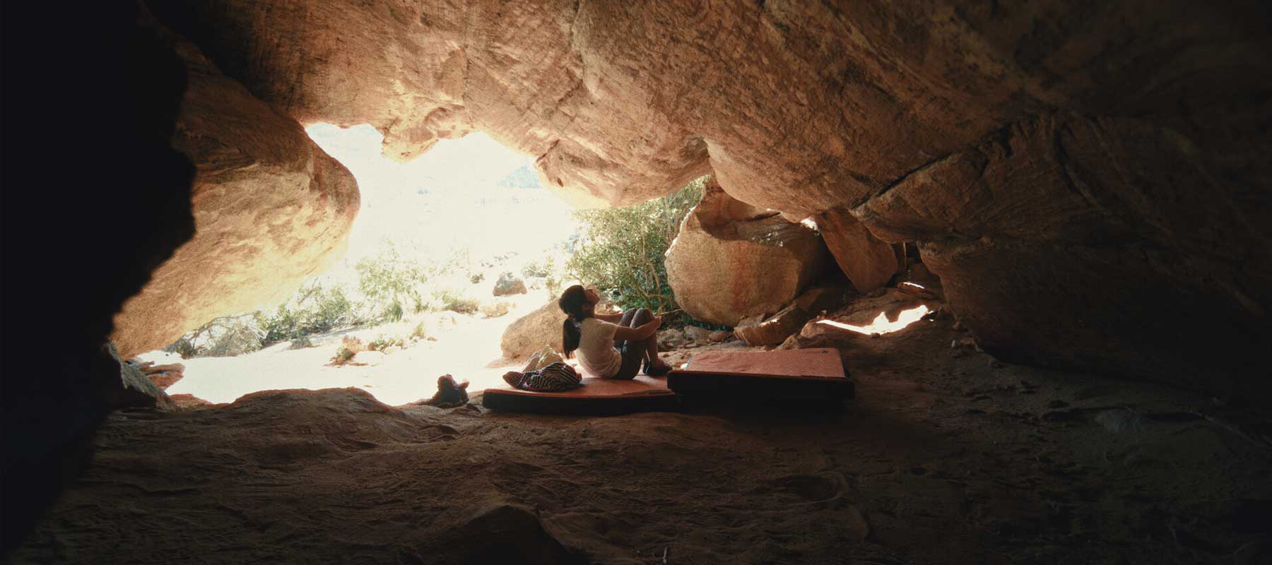 A child climber named Ashima observes a rock formation.